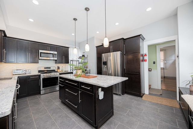 1066 City Park Ave, Columbus, OH 43206 - kitchen with appliances with stainless steel finishes, tasteful backsplash, light stone counters, decorative light fixtures, and recessed lighting