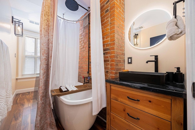 1066 City Park Ave, Columbus, OH 43206 - full bathroom featuring vanity, wood finished floors, and brick wall