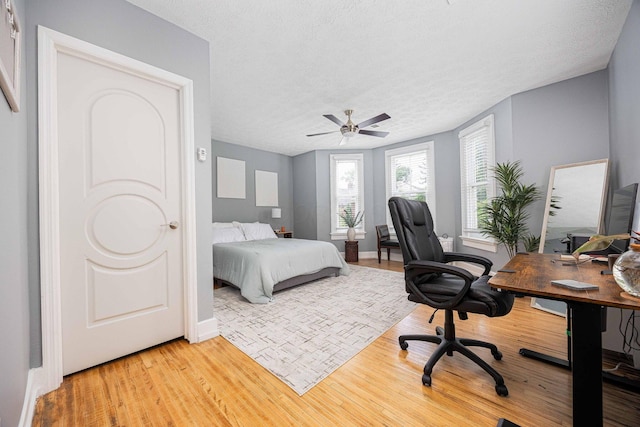 1066 City Park Ave, Columbus, OH 43206 - bedroom featuring light wood finished floors, a desk, a textured ceiling, and a ceiling fan