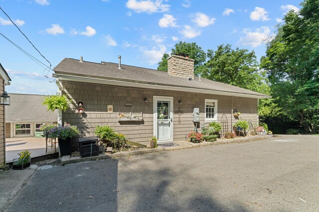 170 Joy Ln, Granville, OH 43023 - view of front of house with a chimney, a shingled roof, and a patio area
