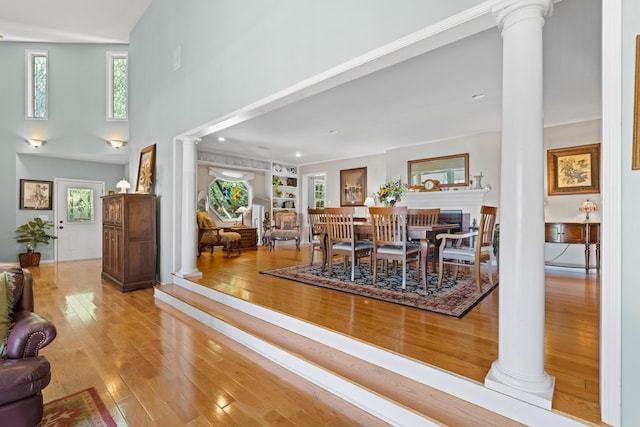 170 Joy Ln, Granville, OH 43023 - dining space featuring ornate columns, wood-type flooring, a towering ceiling, and built in features