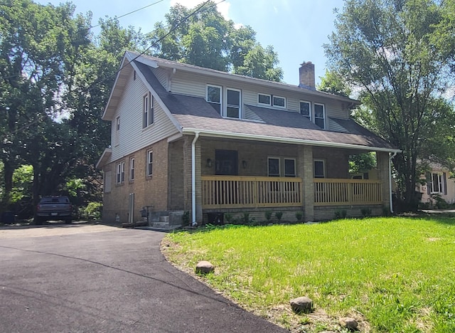 984 N Nelson Rd, Columbus, OH 43219 - view of front facade featuring a chimney, a porch, brick siding, and a front lawn