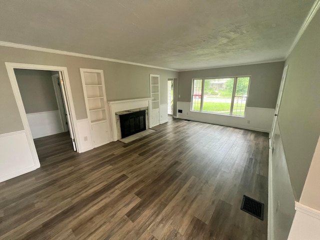 965 Francis Ave, Columbus, OH 43209 - unfurnished living room featuring built in shelves, dark wood finished floors, ornamental molding, a fireplace, and a wainscoted wall