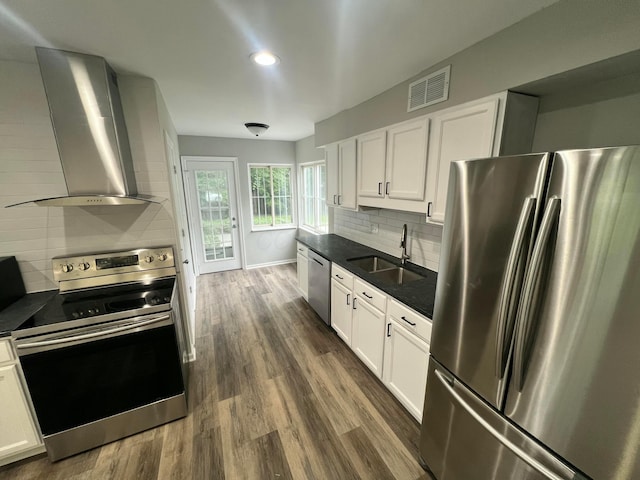 965 Francis Ave, Columbus, OH 43209 - kitchen featuring stainless steel appliances, wall chimney exhaust hood, dark countertops, tasteful backsplash, and white cabinetry