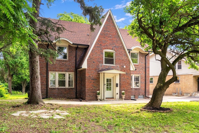 992 N Nelson Rd, Columbus, OH 43219 - tudor-style house with a shingled roof, brick siding, and a front lawn