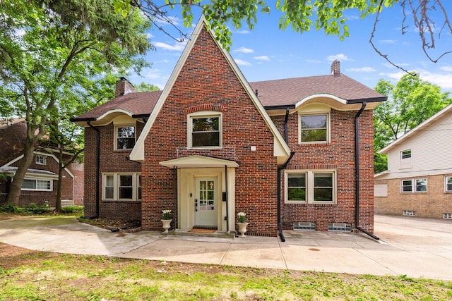 992 N Nelson Rd, Columbus, OH 43219 - tudor-style house featuring a chimney, brick siding, and a shingled roof