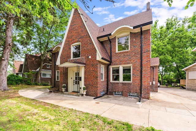 992 N Nelson Rd, Columbus, OH 43219 - tudor-style house featuring brick siding, a shingled roof, and a chimney
