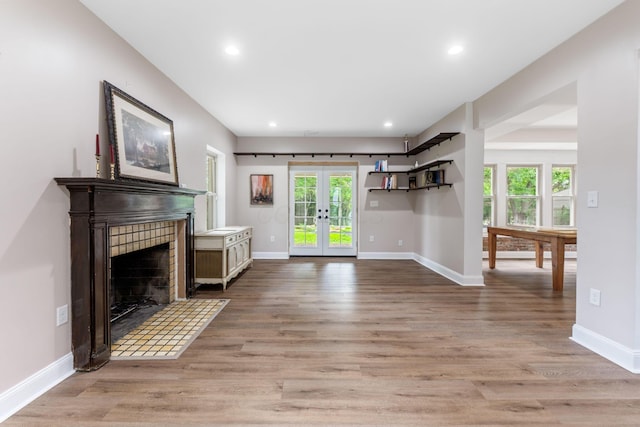 992 N Nelson Rd, Columbus, OH 43219 - unfurnished living room featuring french doors, light wood finished floors, recessed lighting, and a tile fireplace