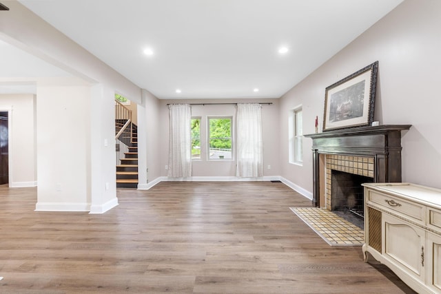 992 N Nelson Rd, Columbus, OH 43219 - unfurnished living room with stairway, a fireplace, light wood finished floors, and recessed lighting