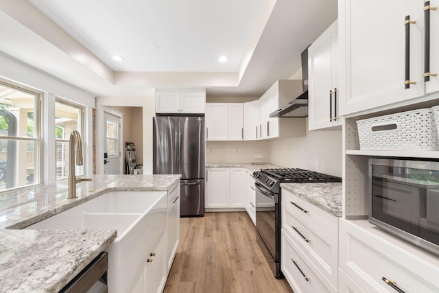 992 N Nelson Rd, Columbus, OH 43219 - kitchen featuring stainless steel appliances, light wood-type flooring, white cabinetry, light stone counters, and a raised ceiling