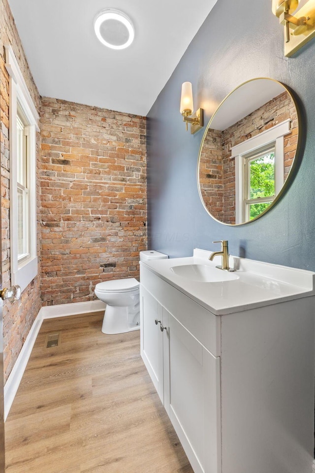 992 N Nelson Rd, Columbus, OH 43219 - bathroom with vanity, wood finished floors, and brick wall