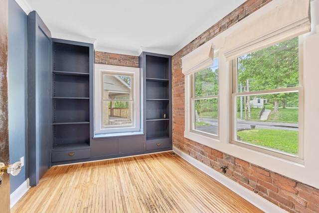 992 N Nelson Rd, Columbus, OH 43219 - empty room with brick wall, wood-type flooring, built in features, and crown molding