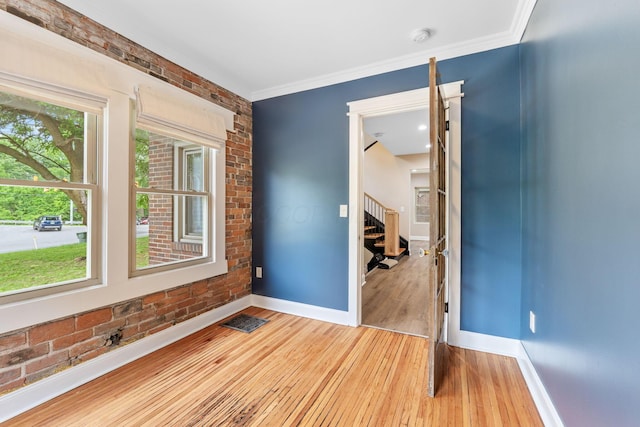 992 N Nelson Rd, Columbus, OH 43219 - spare room with light wood-style flooring, brick wall, stairway, crown molding, and a smoke detector