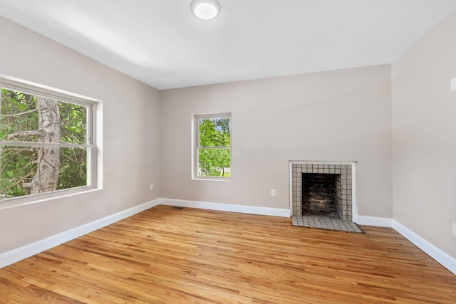992 N Nelson Rd, Columbus, OH 43219 - unfurnished living room with healthy amount of natural light, light wood finished floors, and a fireplace