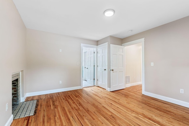 992 N Nelson Rd, Columbus, OH 43219 - unfurnished living room featuring light wood finished floors and a fireplace
