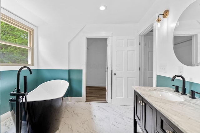 992 N Nelson Rd, Columbus, OH 43219 - full bath featuring marble look tiles, a freestanding bath, recessed lighting, and vanity