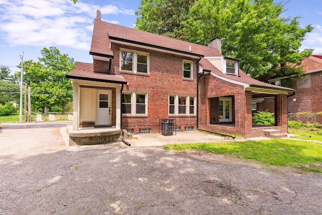 992 N Nelson Rd, Columbus, OH 43219 - back of property featuring a chimney, brick siding, a patio, and roof with shingles