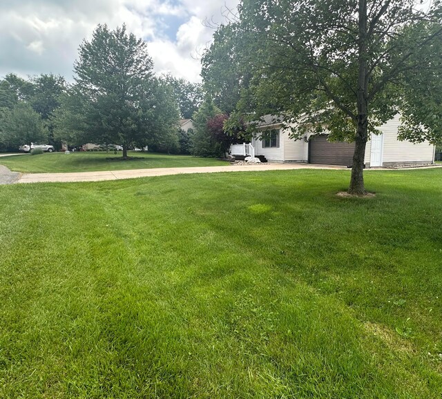 477 Greenlawn Dr, Howard, OH 43028 - view of grassy yard featuring a garage and driveway