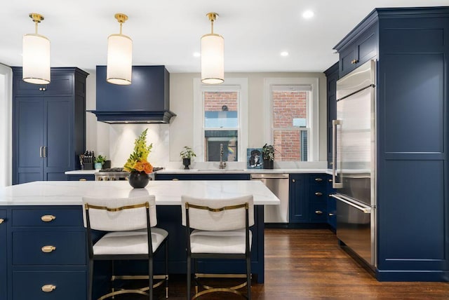 249 E Whittier St, Columbus, OH 43206 - kitchen with appliances with stainless steel finishes, premium range hood, blue cabinetry, decorative light fixtures, and recessed lighting