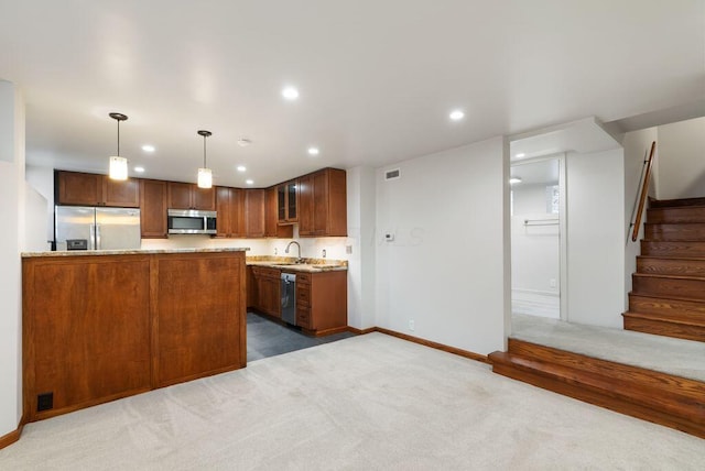249 E Whittier St, Columbus, OH 43206 - kitchen featuring appliances with stainless steel finishes, carpet flooring, recessed lighting, decorative light fixtures, and brown cabinetry
