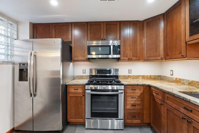 249 E Whittier St, Columbus, OH 43206 - kitchen featuring stainless steel appliances, brown cabinets, and light stone countertops