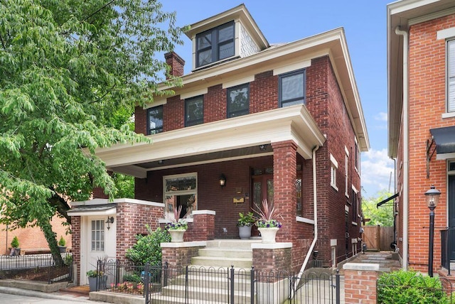 249 E Whittier St, Columbus, OH 43206 - traditional style home with covered porch, brick siding, a fenced front yard, and a gate