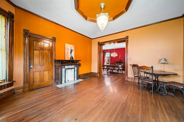 726 Franklin Ave, Columbus, OH 43205 - dining space featuring a premium fireplace, wood-type flooring, crown molding, a tray ceiling, and a chandelier