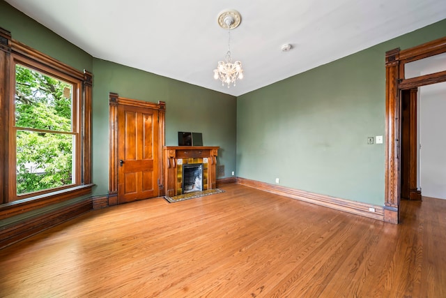 726 Franklin Ave, Columbus, OH 43205 - unfurnished living room featuring a chandelier, wood finished floors, and a fireplace