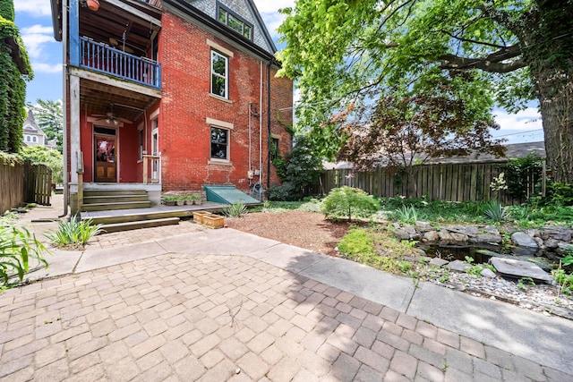 726 Franklin Ave, Columbus, OH 43205 - rear view of property with a balcony, brick siding, a fenced backyard, and a patio