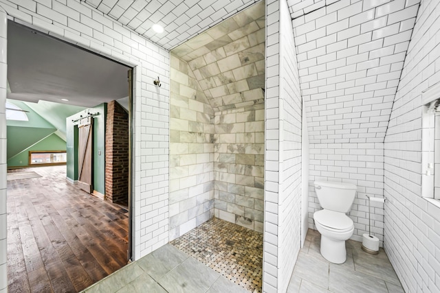 726 Franklin Ave, Columbus, OH 43205 - bathroom with a tile shower, wood finished floors, recessed lighting, and tile walls