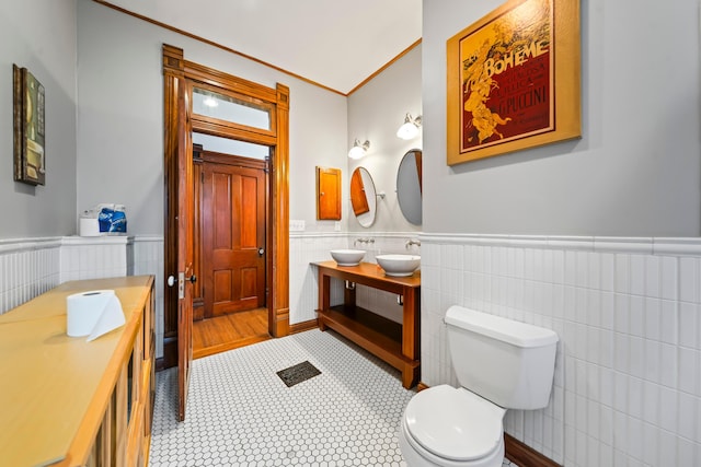 726 Franklin Ave, Columbus, OH 43205 - bathroom with tile walls, a wainscoted wall, double vanity, and ornamental molding