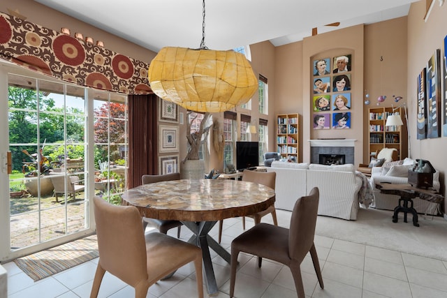 5650 Tynecastle Loop, Dublin, OH 43016 - dining area with a fireplace, light tile patterned flooring, light carpet, and a towering ceiling