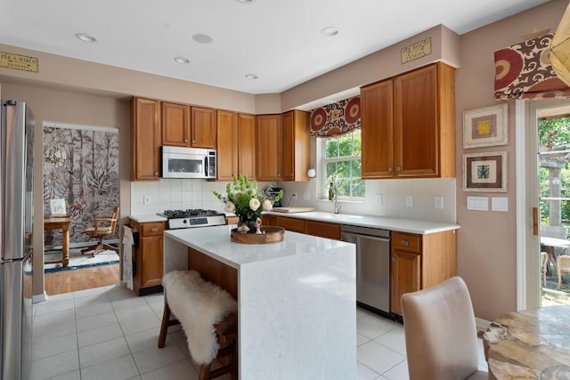 5650 Tynecastle Loop, Dublin, OH 43016 - kitchen featuring appliances with stainless steel finishes, plenty of natural light, brown cabinets, a kitchen island, and recessed lighting