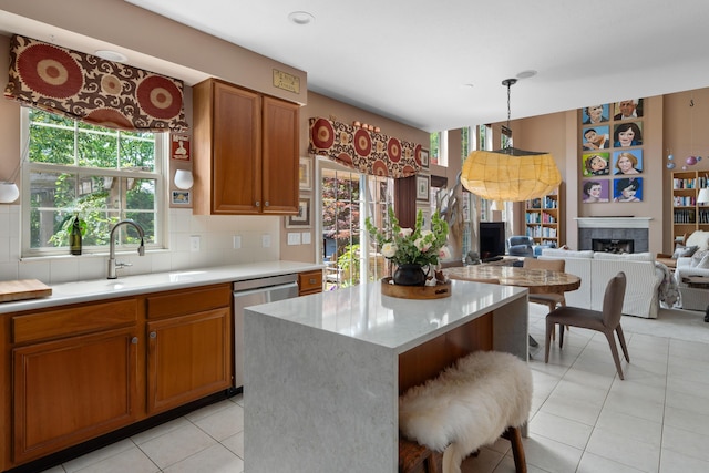5650 Tynecastle Loop, Dublin, OH 43016 - kitchen with stainless steel dishwasher, brown cabinetry, light countertops, and open floor plan