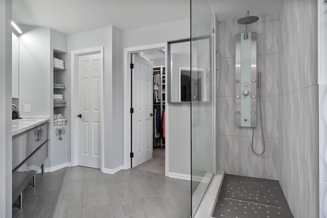 5650 Tynecastle Loop, Dublin, OH 43016 - full bathroom with a tile shower, a walk in closet, vanity, and tile patterned flooring