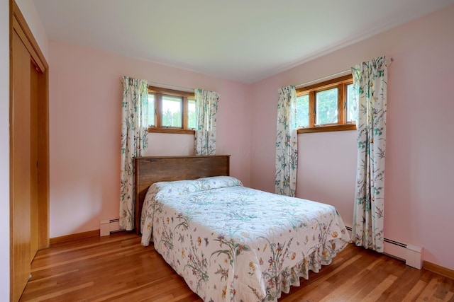 3180 Sitterley Rd NW, Canal Winchester, OH 43110 - bedroom with a baseboard radiator, multiple windows, and wood finished floors