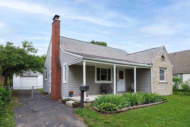 335 Letchworth Ave, Columbus, OH 43204 - view of front facade featuring an outdoor structure, driveway, stone siding, a shingled roof, and a front yard
