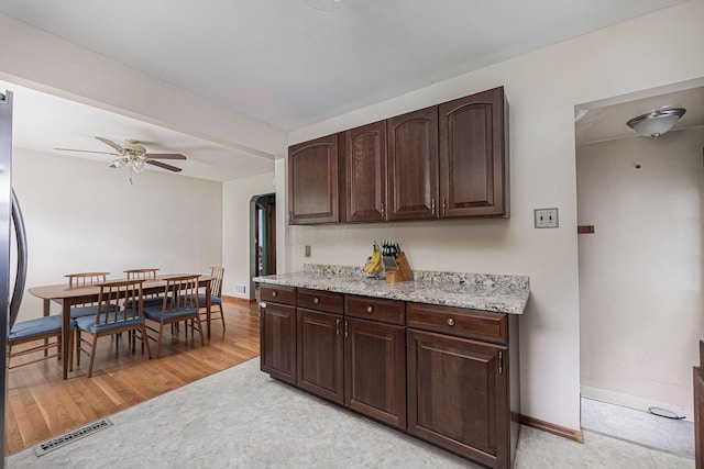 335 Letchworth Ave, Columbus, OH 43204 - kitchen featuring dark brown cabinetry, ceiling fan, light stone counters, and light flooring