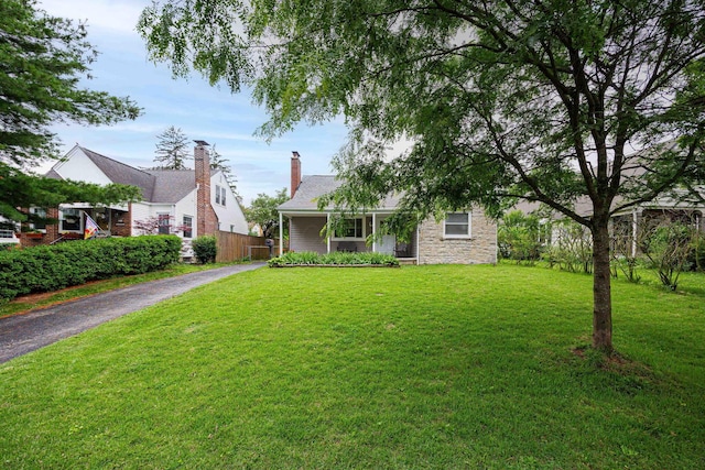 335 Letchworth Ave, Columbus, OH 43204 - view of front facade with stone siding, asphalt driveway, a front lawn, and covered porch