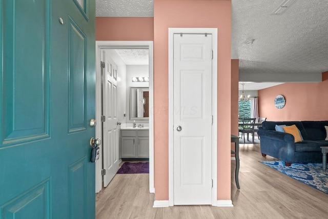 7780 Freesia St Unit 228, Blacklick, OH 43004 - entrance foyer with light wood finished floors, a textured ceiling, and a chandelier