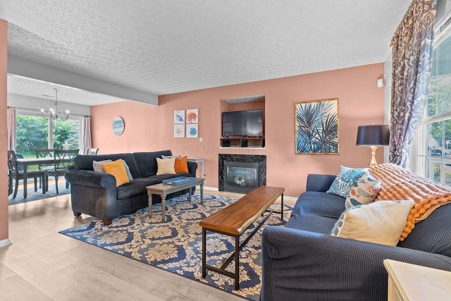 7780 Freesia St Unit 228, Blacklick, OH 43004 - living room with a textured ceiling, wood finished floors, a chandelier, and a glass covered fireplace
