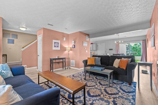 7780 Freesia St Unit 228, Blacklick, OH 43004 - living room featuring a chandelier, a textured ceiling, and light wood-style floors