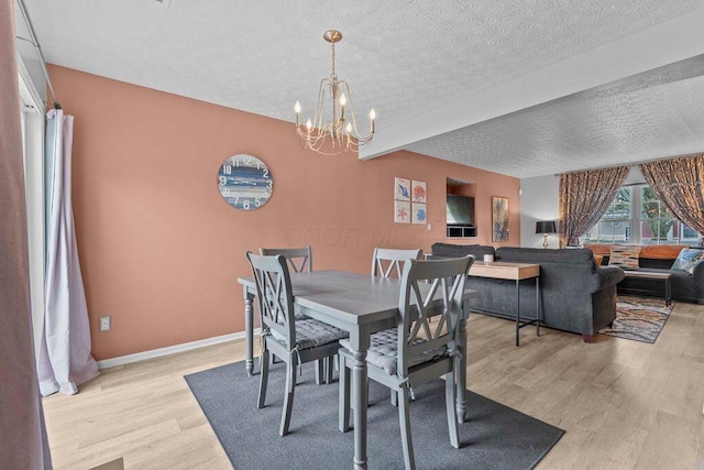 7780 Freesia St Unit 228, Blacklick, OH 43004 - dining area with light wood-type flooring, a chandelier, beamed ceiling, and a textured ceiling