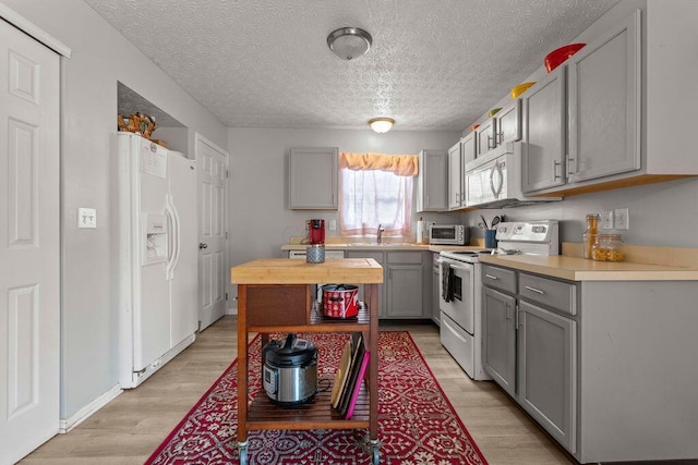7780 Freesia St Unit 228, Blacklick, OH 43004 - kitchen with white appliances, gray cabinetry, light wood-type flooring, butcher block countertops, and a textured ceiling
