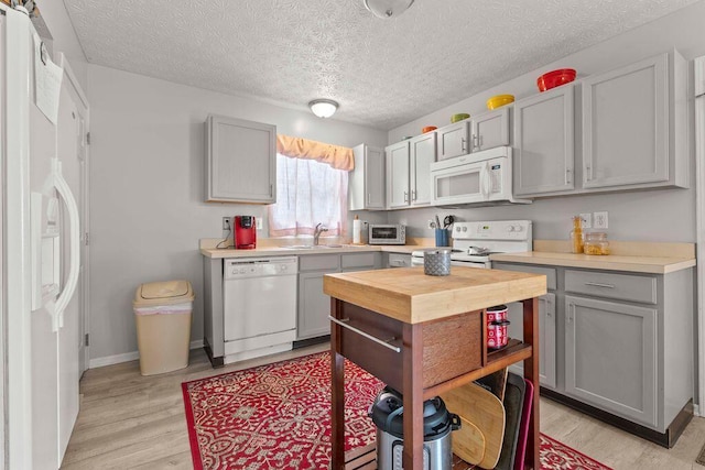 7780 Freesia St Unit 228, Blacklick, OH 43004 - kitchen with white appliances, gray cabinets, light wood-type flooring, butcher block countertops, and a textured ceiling
