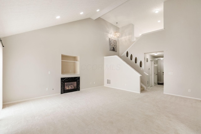 5595 Marshfield Dr, Westerville, OH 43081 - unfurnished living room with high vaulted ceiling, stairs, light colored carpet, a high end fireplace, and recessed lighting