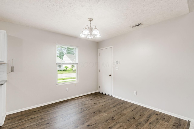 5595 Marshfield Dr, Westerville, OH 43081 - unfurnished dining area featuring dark wood-type flooring, a chandelier, and a textured ceiling