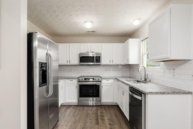5595 Marshfield Dr, Westerville, OH 43081 - kitchen featuring stainless steel appliances, dark wood-style flooring, light stone countertops, white cabinets, and decorative backsplash