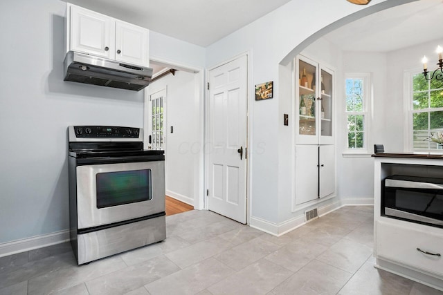 208 S Stanwood Rd, Bexley, OH 43209 - kitchen featuring stainless steel appliances, under cabinet range hood, arched walkways, white cabinetry, and light tile patterned floors