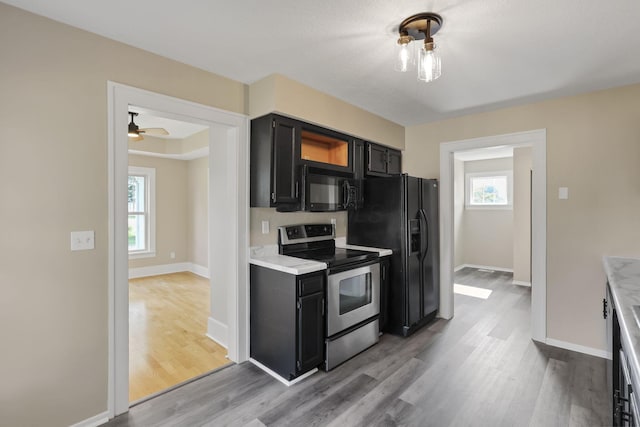 156 E Postal Ave, Newark, OH 43055 - kitchen with black appliances, dark cabinetry, light wood-style floors, and light countertops